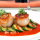 A photo of seared scallops and grilled zucchini on a roasted red pepper sauce